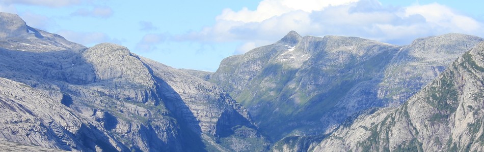 Foto av dypt nedskåret dallandskap under skoggrensen med innsjø