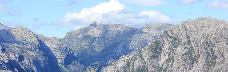 Foto av nedskåret dallandskap med hei over skoggrensen med innsjø