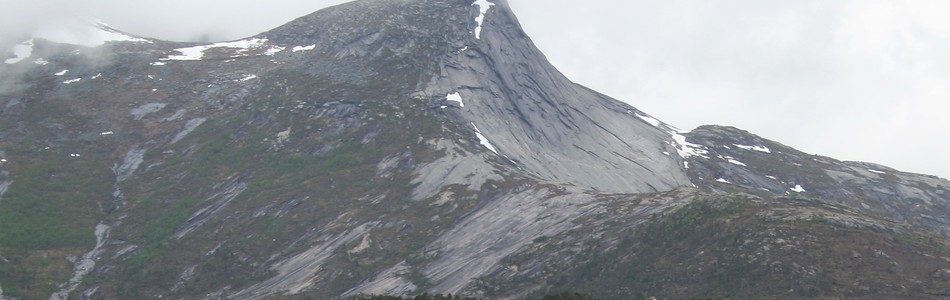Foto av tindepreget ås- og fjellandskap under skoggrensen