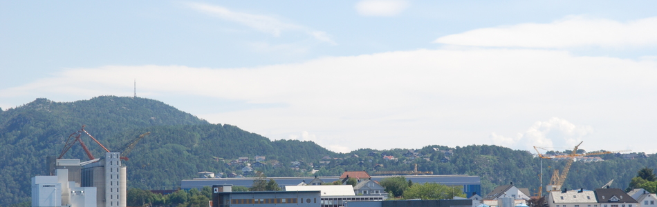 Foto av middels eksponert ytre slakt til småkupert kystslettelandskap med tett bebyggelse